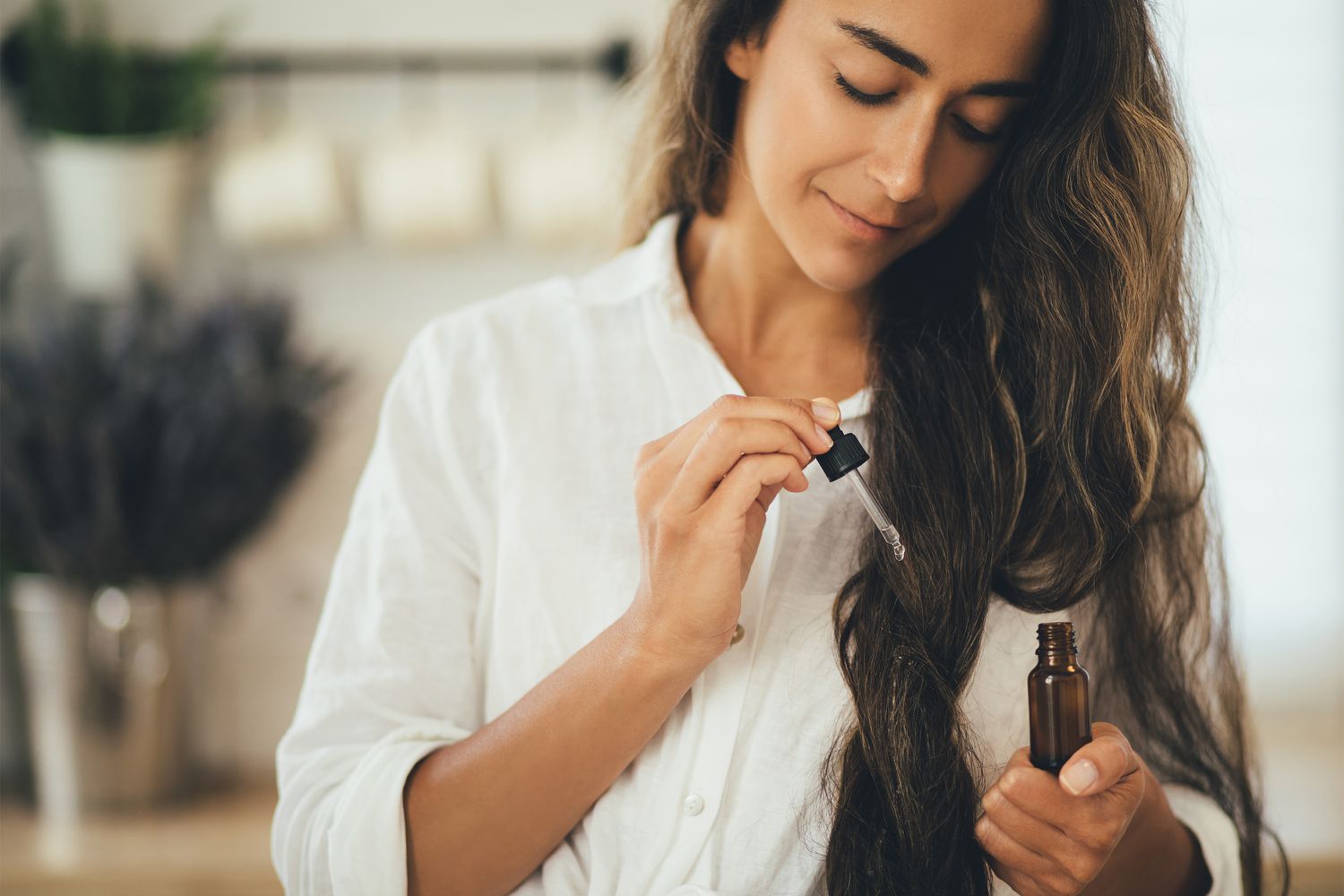 Woman applying hair oil for maximum benefits